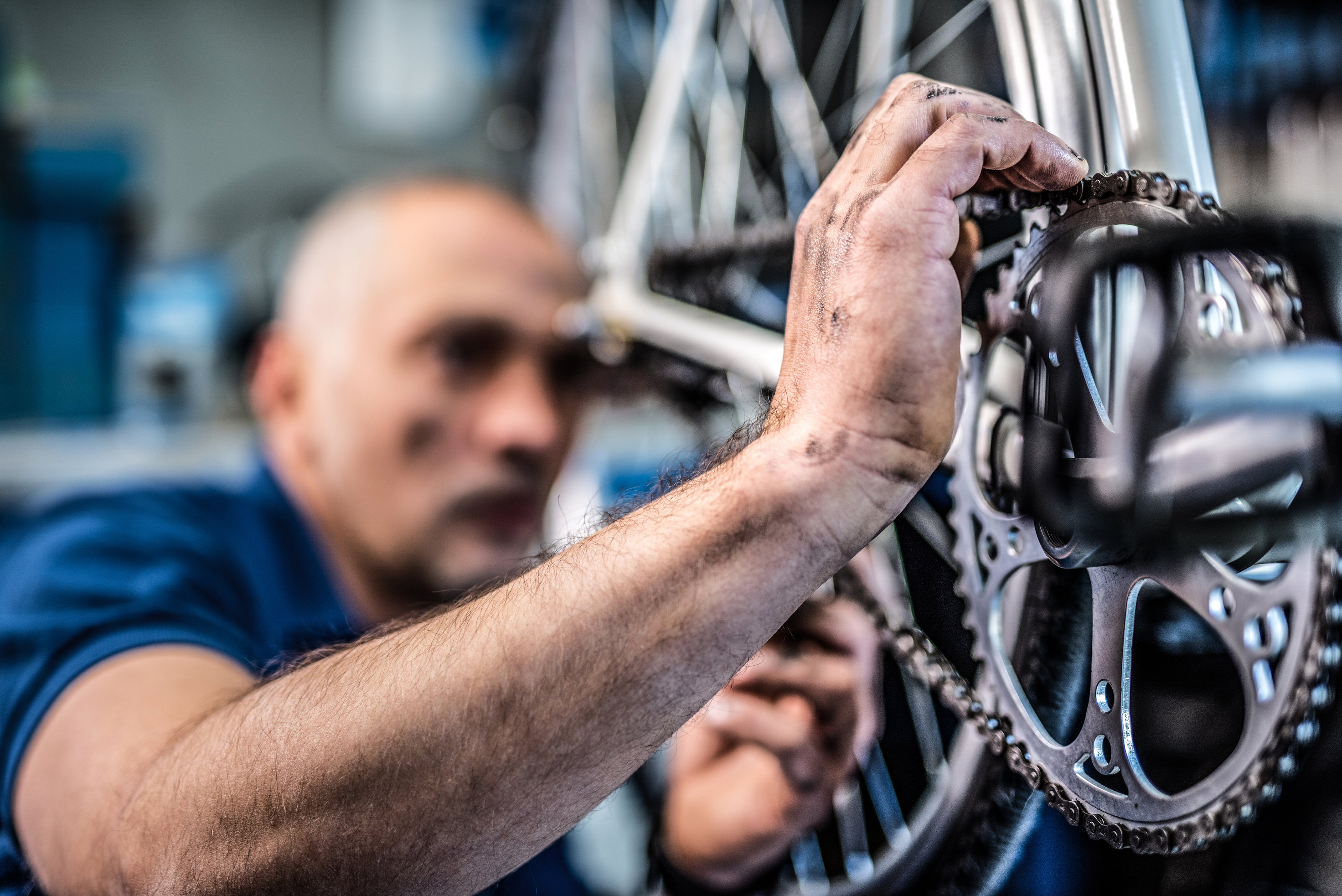 Bicycle technician repairing bicycle transmission.